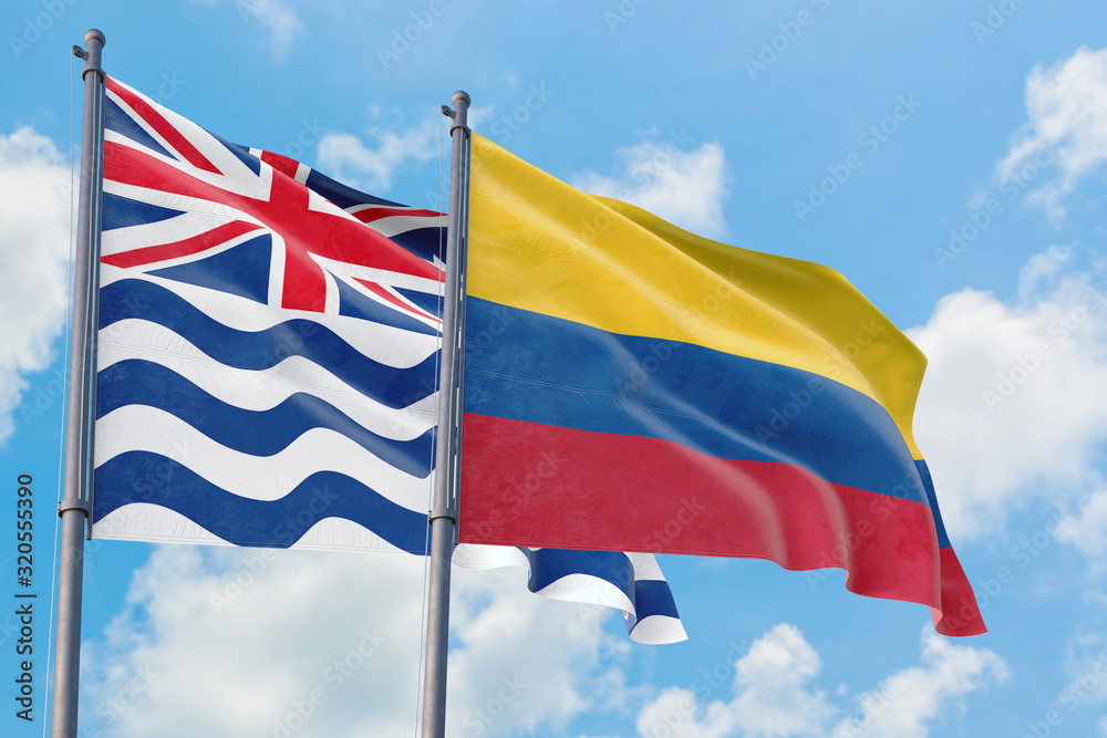 Colombia and British Indian Ocean Territory flags waving in the wind against white cloudy blue sky together. Diplomacy concept, international relations.