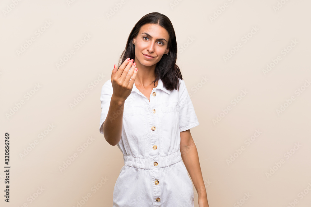 Young woman over isolated background inviting to come with hand. Happy that you came Young woman over isolated background inviting to come with hand. Happy that you came