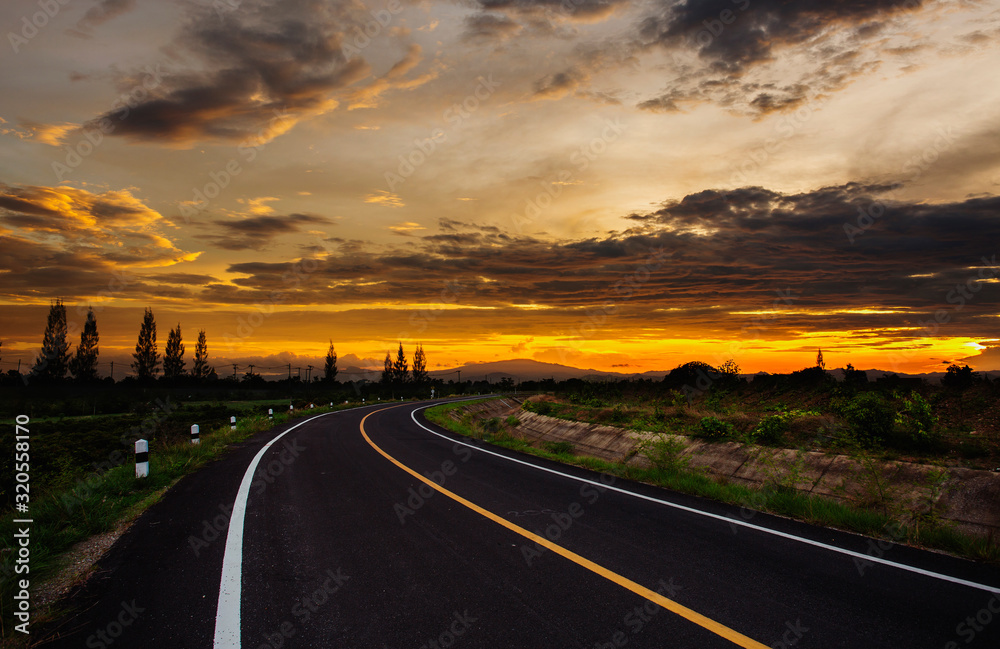 open road with beautiful sunset and golden sky.  Highland road.