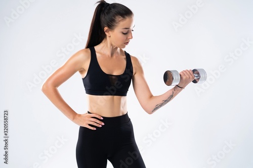 beautiful sporty muscular woman working out with two dumbbells © opolja