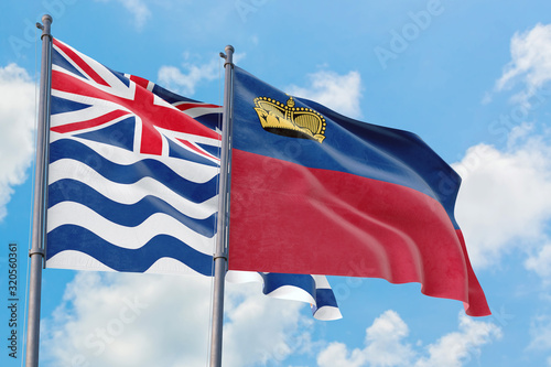 Liechtenstein and British Indian Ocean Territory flags waving in the wind against white cloudy blue sky together. Diplomacy concept  international relations.