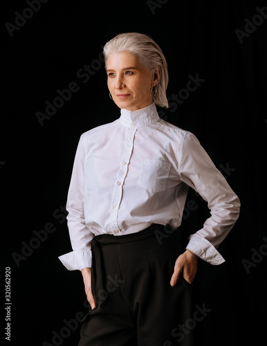 Business senior woman in white shirt on black background
