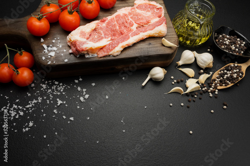 Prepare fresh beef steak with ingredients. Placed on a black background