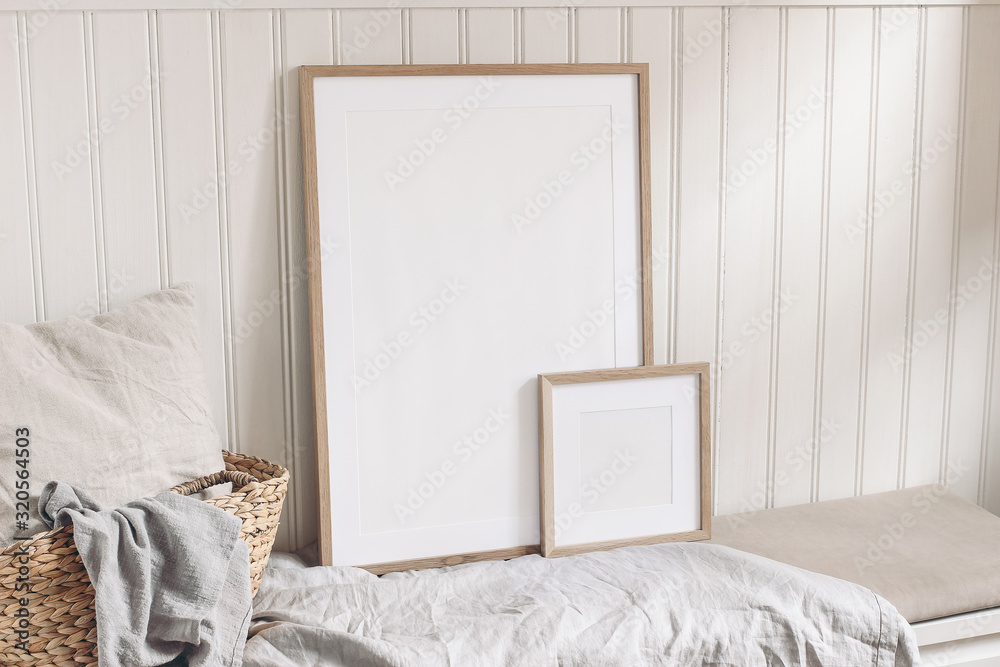 Portrait and square empty wooden frame mockups with straw basket and linen cloth. White beadboard wainscot wall paneling background. Scandinavian interior, home design. Art concept. - obrazy, fototapety, plakaty 