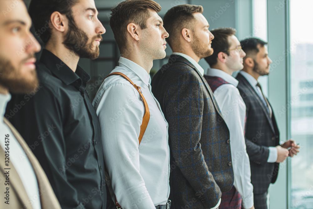 side view on young caucasian bearded business people looking side at panoramic window, everyone in stylish elegant suit. isolated in modern office side view on young caucasian bearded business people looking side at panoramic window, everyone in stylish elegant suit. isolated in modern office