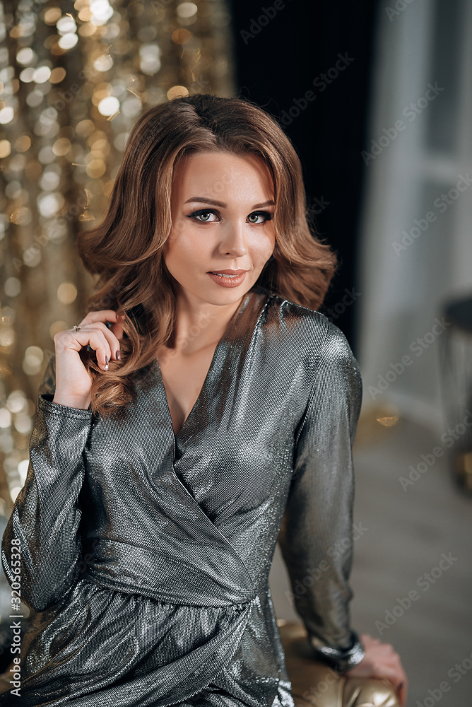 shiny woman in a silver dress on a gold background shiny woman in a silver dress on a gold background