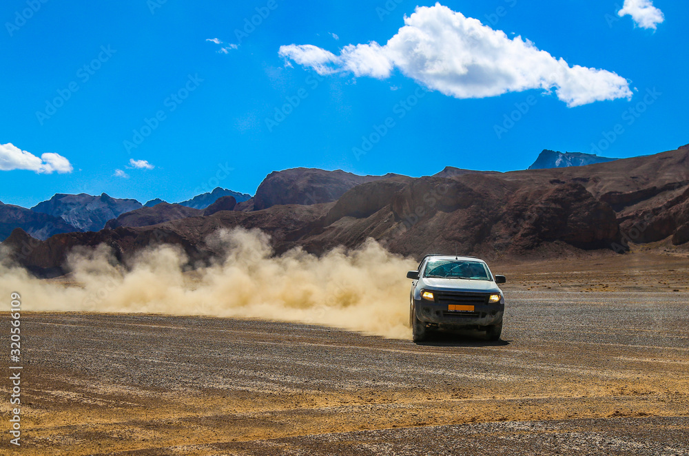 SUV raises clouds of dust on a mountain plateau SUV raises clouds of dust on a mountain plateau