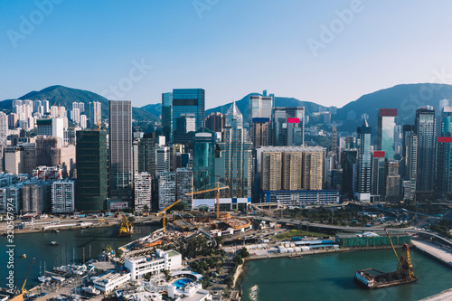 Aerial scenery panoramic view from drone of Hong Kong skyscrapers skyline with metropolitan bay. Modern concrete cityscape of urban downtown with business and financial buildings. City infrastructure