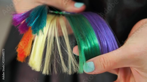 The client of hair salon chooses the color of hair dyeing on catalog. Close up.
