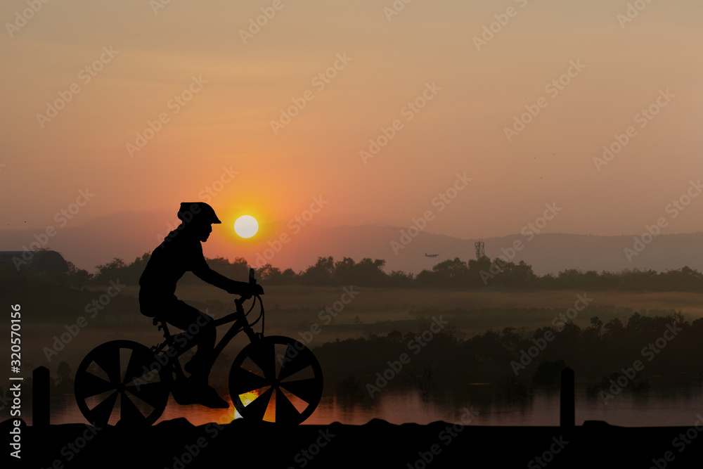 Fototapeta premium Silhouettes Man and bicycle on mountain in the sunlight