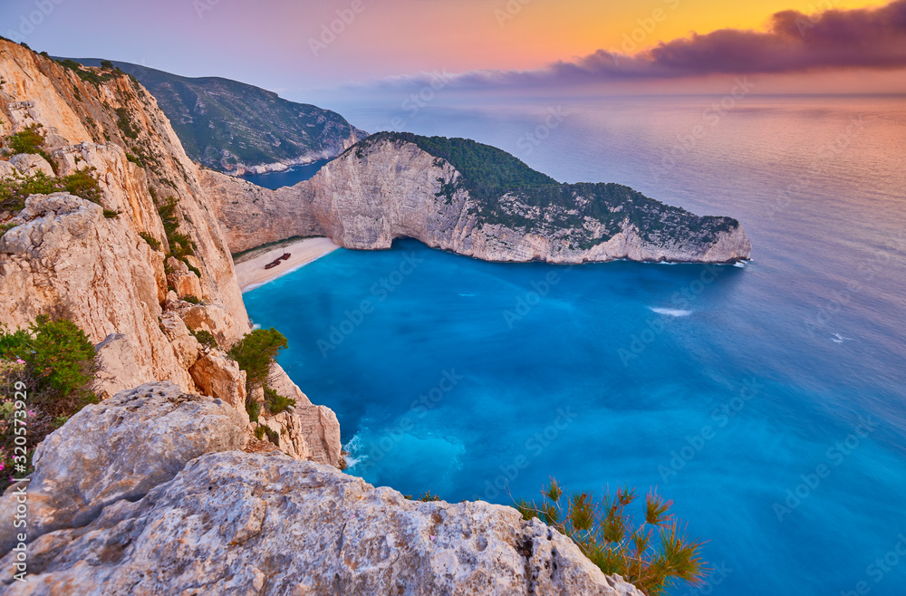 Navagio Beach with shipwreck view on Zakynthos island, Greece. Incredibly romantic sunrise on Zakinthos. Amazing sunset view with multicolored clouds. Island of lovers. Doors to heaven