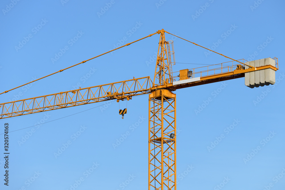 construction tower crane against the blue sky