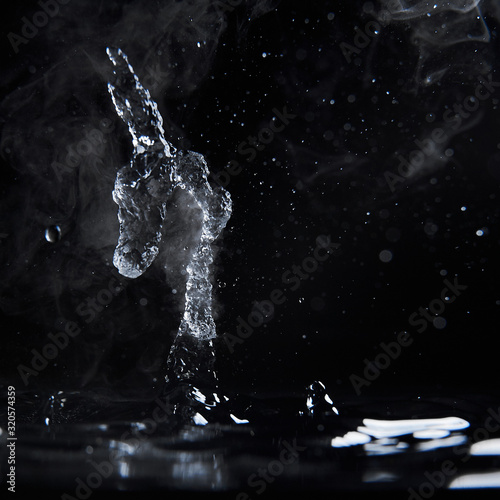 Obraz na płótnie Boiling water splash with steam on black background closeup