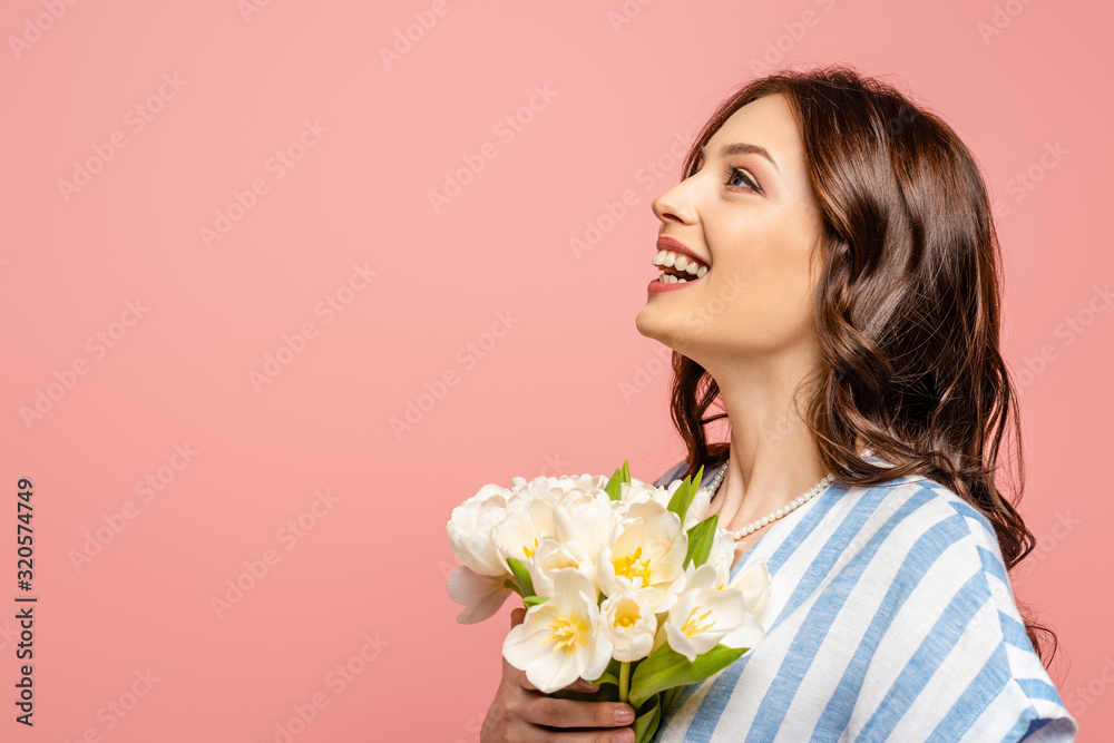 happy girl looking up while holding bouquet of white tulips isolated on pink happy girl looking up while holding bouquet of white tulips isolated on pink