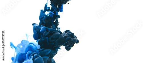 Mix of black and classic blue ink in water on an isolated white background with copy space. photo