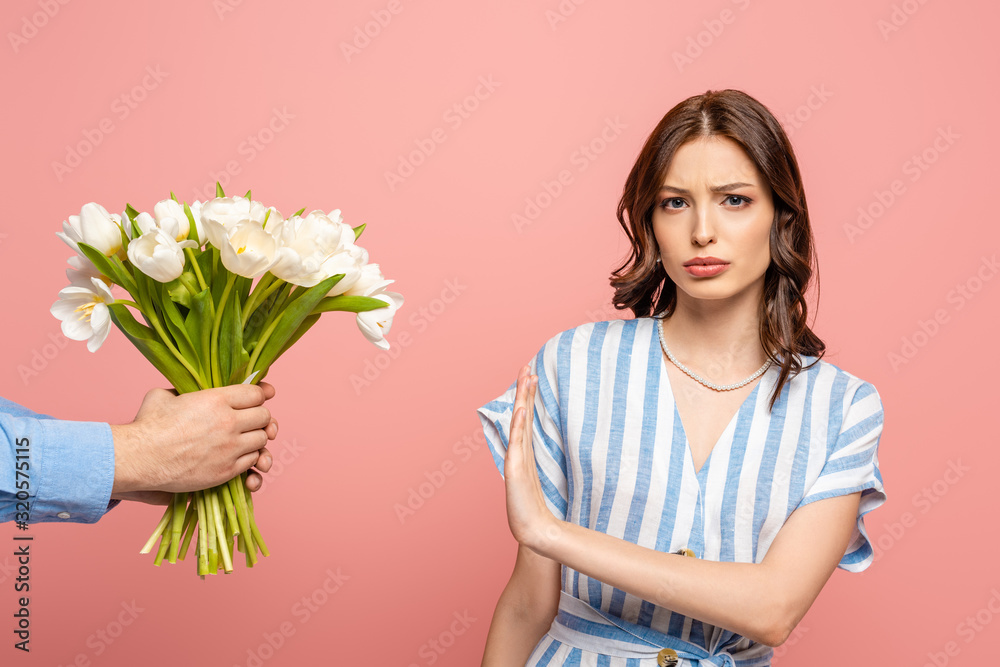 partial view of man presenting bouquet of white tulips to displeased girl showing no gesture isolated on pink partial view of man presenting bouquet of white tulips to displeased girl showing no gesture isolated on pink