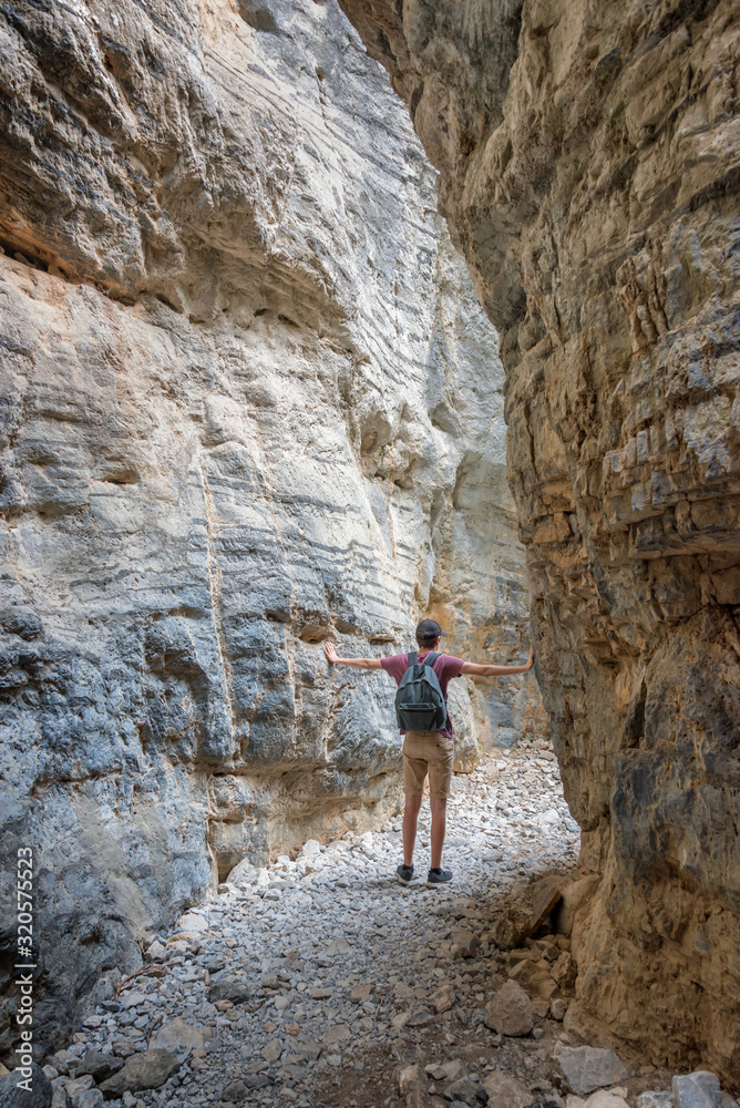 Hiker in a narrow trail of Imbros gorge, Crete, Greece