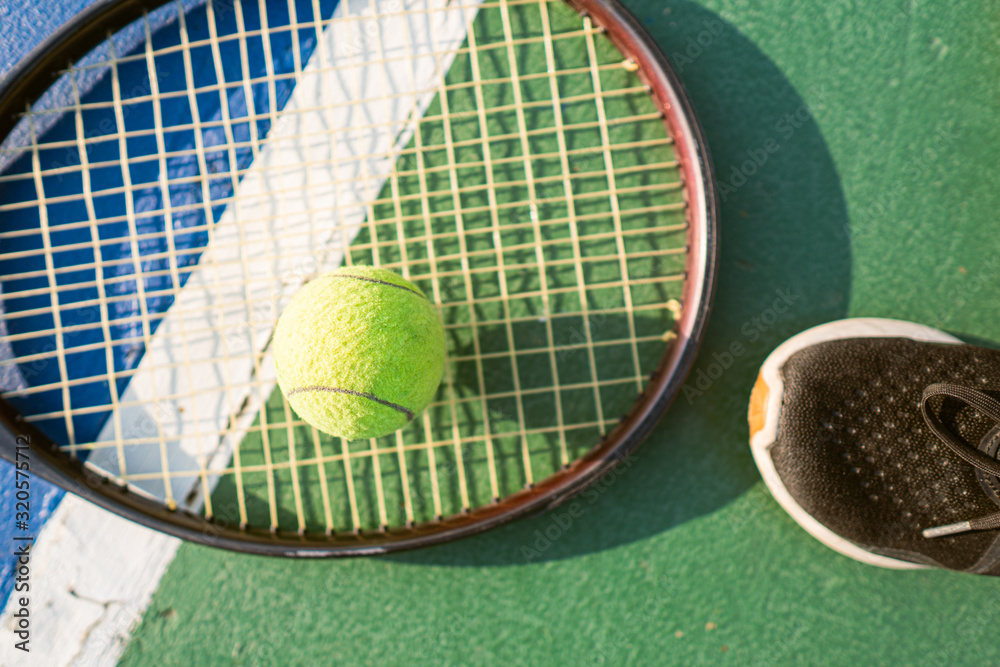 Φωτογραφία yellow tennis ball on the floor of the tennis court with racket and shoe