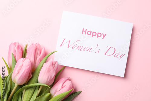 Pink tulips and inscription Happy women's day on pink background, top view
