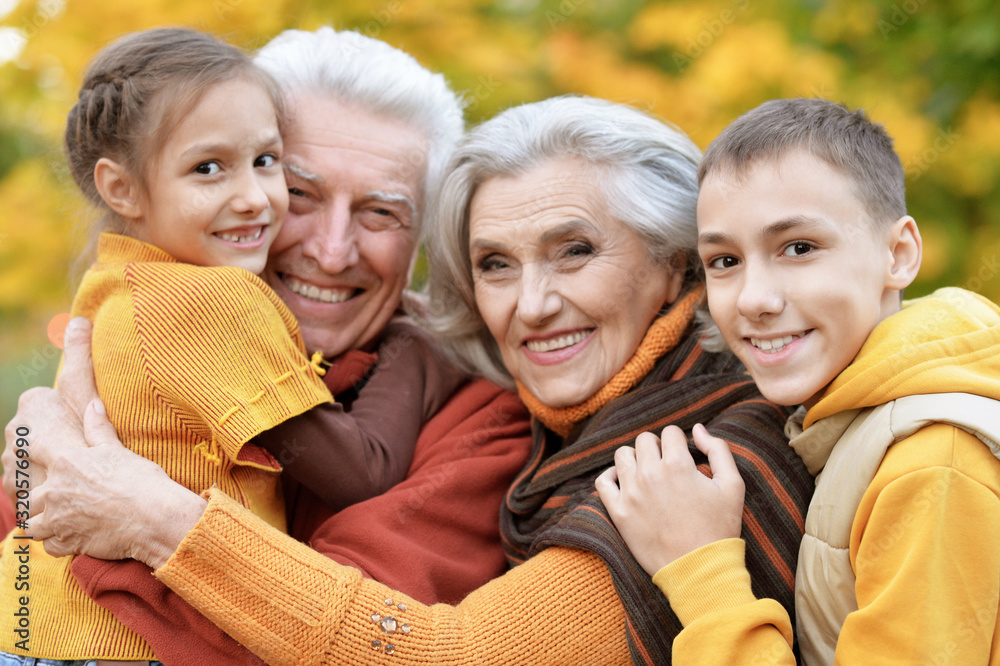 Fototapeta premium Happy grandfather, grandmother and grandchildren in park