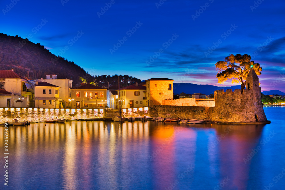Panoramic view of the illuminated port of Nafpaktos, Greece. Nafpaktos is a popular tourist destination and a picturesque coastal town, former municipality in Aetolia-Acarnania, West Greece