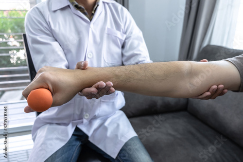 Doctor physiotherapist treating rehabilitation arm pain patient doing physical therapy exercises with his therapist treatment on stretching in clinic - sport physical therapy concept