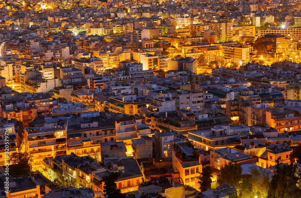 An evening cityscape of many buildings of Athens City, Greece. View from Filopappou Hill or Hill of the Muses. Colorful spring landscape. Urban skyscraper skyline rooftop view at night. An evening cityscape of many buildings of Athens City, Greece. View from Filopappou Hill or Hill of the Muses. Colorful spring landscape. Urban skyscraper skyline rooftop view at night.