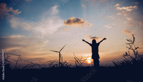 Blured Lady's silhouette raised arms with sunset sky for relax and happy concept