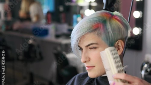 Coloring hair in a barbershop. Multicolored dyeing. A short pixie haircut.