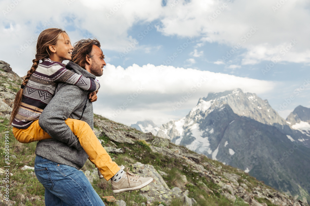 Father with child walking on the mountain and enjoying beautiful view