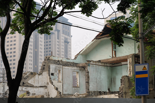 Destroyed building in Chinese city, modern construction in background