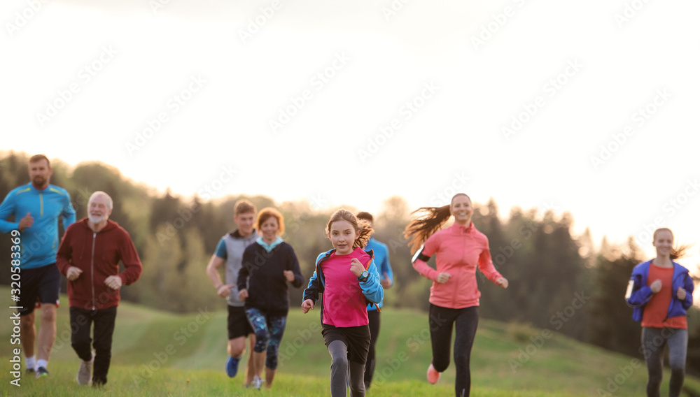 A large group of people cross country running in nature. A large group of people cross country running in nature.