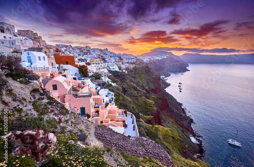 Multicolored clouds of the morning dawn. Fira town on Santorini island, Greece. Incredibly romantic sunrise on Santorini. Oia village in the morning light. Amazing sunset view with white houses.