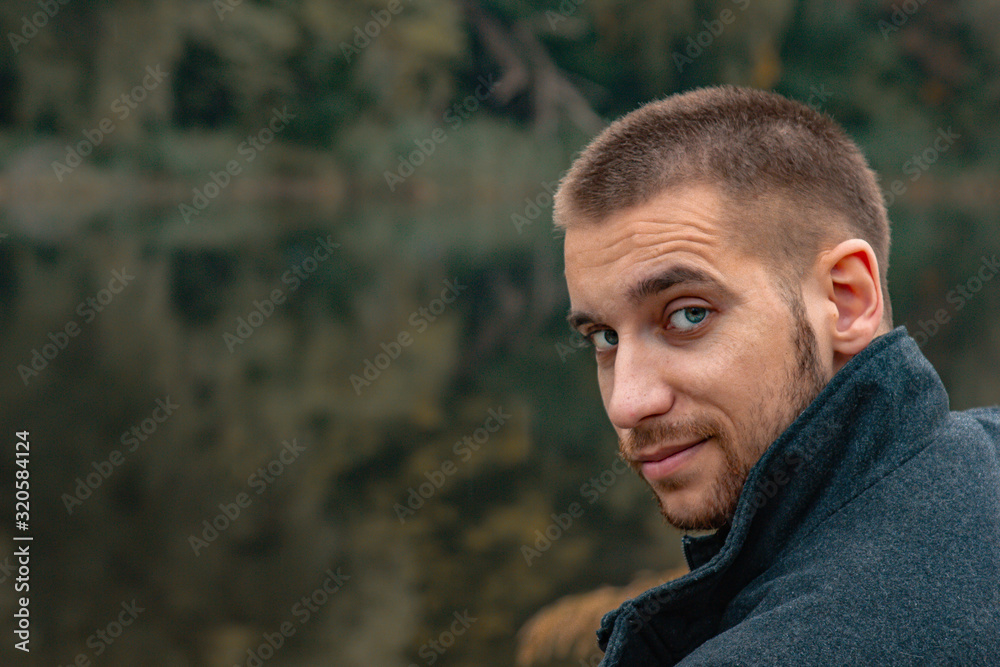A guy with a beard sits on the lake and smokes an electronic cigarette. Blows puffs of smoke. The concept of unity with nature. Rest near the water. Vape, Man Vaping. lips and smoke, a lot of smoke. A guy with a beard sits on the lake and smokes an electronic cigarette. Blows puffs of smoke. The concept of unity with nature. Rest near the water. Vape, Man Vaping. lips and smoke, a lot of smoke.