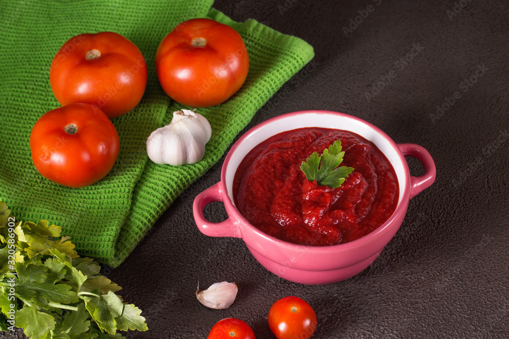 Tomato soup with parsley, onion and garlic on gray background. Comfortable food. Rustic style.. Tomato soup with parsley, onion and garlic on gray background. Comfortable food. Rustic style..