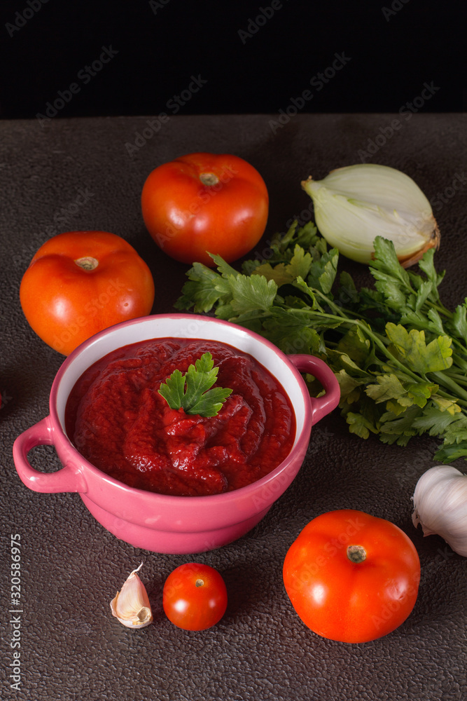 Tomato soup with parsley, onion and garlic on gray background. Comfortable food. Rustic style.. Tomato soup with parsley, onion and garlic on gray background. Comfortable food. Rustic style..