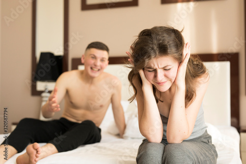 Couple quarreling in bedroom during relationship conflict