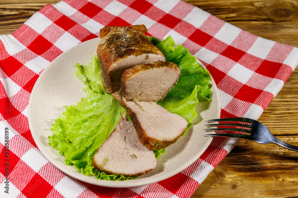 Tasty baked pork with spices on a wooden table