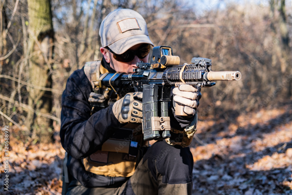 Fototapeta premium Male from private military company with rifle in the forest