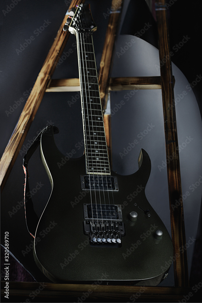 art photo of an electric guitar on a stand, black background
