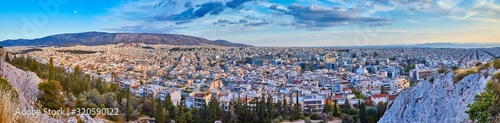 An evening cityscape of many buildings of Athens City, Greece. View from Filopappou Hill or Hill of the Muses. Colorful spring landscape. Urban skyscraper skyline rooftop view at night.