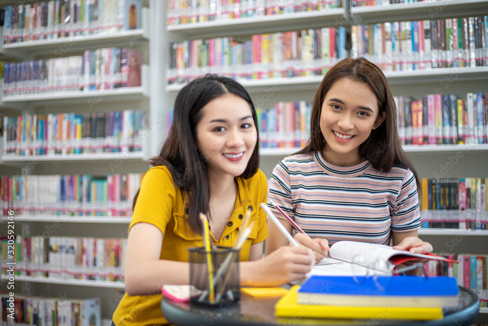 Group Asian Students Smile and reading book and using notebook for helps to share ideas in the work and project. And also review the book before the exam Group Asian Students Smile and reading book and using notebook for helps to share ideas in the work and project. And also review the book before the exam
