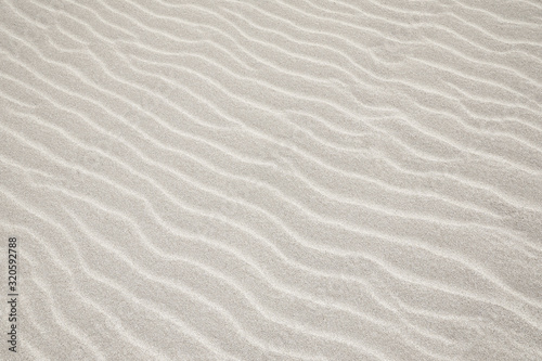 White Sand dunes background texture. Beach and sand texture. Pattern of sand. Beautiful sand dune in sunrise in the desert. Steps on the beach sand. photo