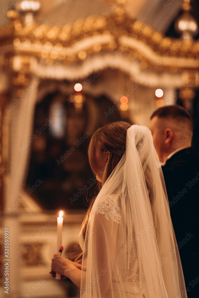 Orthodox church, sacrament of a wedding ceremony, couple, priest, golden church interior, candles, icons, altar, prayer