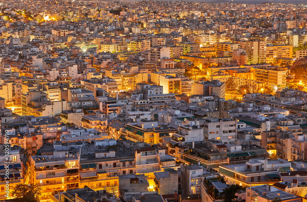 An evening cityscape of many buildings of Athens City, Greece. View from Filopappou Hill or Hill of the Muses. Colorful spring landscape. Urban skyscraper skyline rooftop view at night. An evening cityscape of many buildings of Athens City, Greece. View from Filopappou Hill or Hill of the Muses. Colorful spring landscape. Urban skyscraper skyline rooftop view at night.