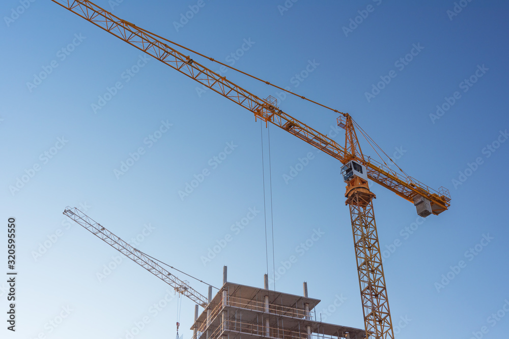 Construction site with high-rise construction cranes.
