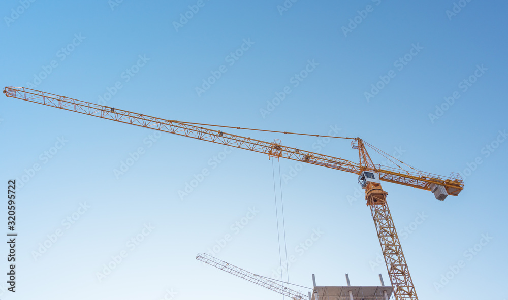 Construction site with high-rise construction cranes.