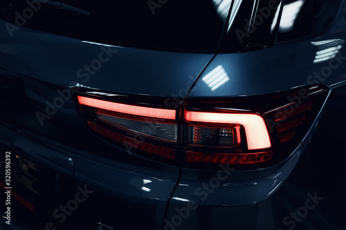 Detail on the rear light of a car. Car detail. Developed Car's rear brake light. The car is in the showroom. Automotive concept. Classic blue color