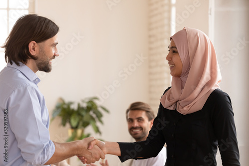 Happy multiethnic business partners handshake at meeting © fizkes