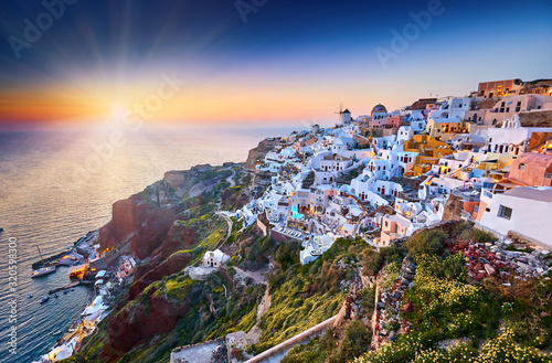 Fira town on Santorini island, Greece. Incredibly romantic sunset on Santorini. Oia village with mills in the evening light. Amazing sunset view with white houses. Island of lovers